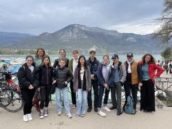 Das Foto zeigt eine Gruppe Schüler vor einem Berg am Ufer des Lac d’ Annecy